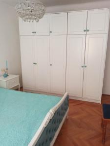 una camera da letto con un letto con armadi bianchi e un lampadario a braccio di Alanis a Vela Luka (Vallegrande)
