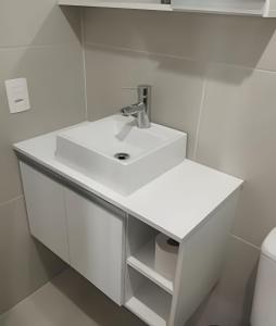 a white bathroom with a sink and a toilet at Apartamento Central com suite Panazzolo 7 minutos do centro in Caxias do Sul +27 photos