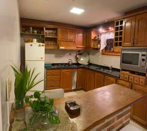 a kitchen with wooden cabinets and a white refrigerator at Vila Bela in Tigre