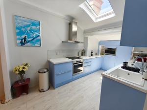 a kitchen with blue and white cabinets and a skylight at Location vacances T3 à Cannes in Cannes +22 photos
