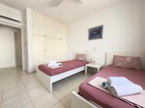 a bedroom with two beds with pink and purple sheets at King's Palace nice apartments 2bd, 2bath sea view in Paphos City