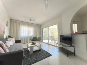 a living room with a couch and a tv at King's Palace nice apartments 2bd, 2bath sea view in Paphos City