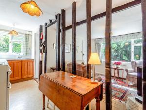 une cuisine et un salon avec un bureau en bois dans une pièce dans l'établissement Oaklawn Cottage, à Eye