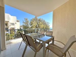 a patio with a table and chairs on a balcony at King's Palace nice apartments 2bd, 2bath sea view in Paphos City
