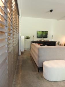 a living room with a couch and a tv on a wall at Casa Milo in Lokeren