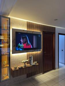 Un televisor de pantalla plana en la pared de una habitación. en Résidence Oubaha - Grand appartement avec piscine, en Mohammedia