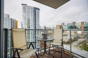 a balcony with a table and chairs and a city at Gorgeous Unit with City Views in Vancouver
