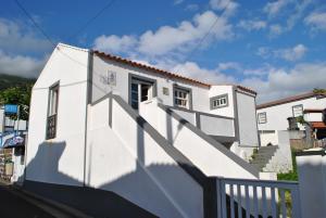 un edificio blanco con una escalera delante en Cantinho do mar, en Urzelina