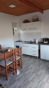 Una cocina con una mesa y sillas de madera en una habitación. en Casitas de Ale en Sierra Ventana, en Sierra de la Ventana