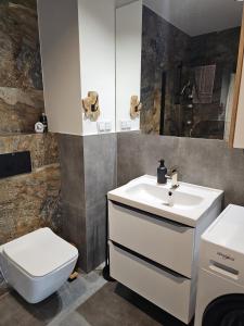 a bathroom with a sink and a toilet at Czarny Słoń - elegancki apartament z klimatem in Częstochowa +60 photos