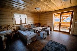 - un salon avec un canapé et une table dans une cabine dans l'établissement Chata Bučina, à Oravská Lesná