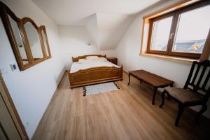 une chambre avec un lit, une chaise et une fenêtre dans l'établissement Chata Bučina, à Oravská Lesná