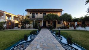 a house with a walkway in front of a yard at Mirsini Apartments in Agios Georgios