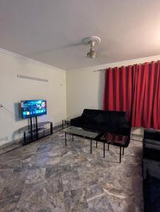 a living room with a couch and a flat screen tv at Holiday inn in Islamabad