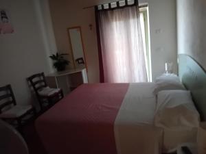 a bedroom with a bed and a window with chairs at Agriturismo Antica Corte in Montatteglia