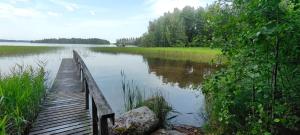 un ponte di legno su un grande bacino d'acqua di Ylisen Kartano a Kaihari Altre 5 foto