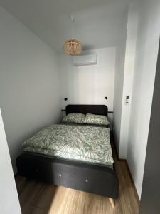 a small bedroom with a bed in the corner at Apartament Szmaragd in Gliwice