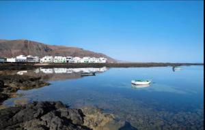 two boats in a body of water with buildings in the background at Casa Paco in Orzola