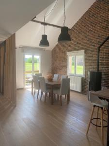 a dining room with a table and chairs and a brick wall at Les Épinettes Appartement 6 in Prémanon