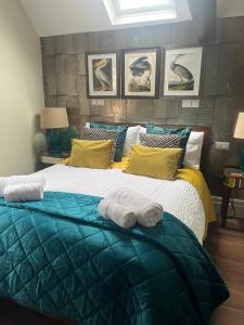 ein Schlafzimmer mit einem großen Bett mit Handtüchern darauf in der Unterkunft Tower Cottage - Medieval Grid Townhouse in Bury Saint Edmunds