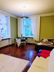 una stanza con due letti, un tavolo e finestre di Ylisen Kartano a Kaihari