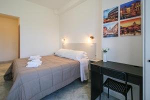 a bedroom with a bed and a desk with towels at Fiumicino King's Guest House - Comfort Rooms in Fiumicino