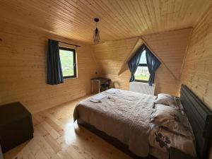 a bedroom with a bed in a wooden cabin at Casa KamArea in Kazbegi
