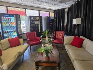 a store with couches and red chairs and a table at Ramada by Wyndham Savannah Gateway in Savannah