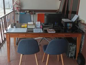 una oficina con un escritorio con dos sillas y una computadora en Kostel 77 Jepara, en Jepara