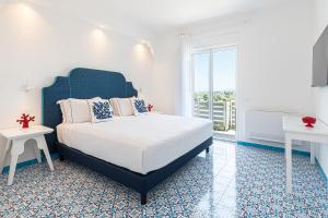 ein Schlafzimmer mit einem großen Bett und einem großen Fenster in der Unterkunft Lea Residenza Mediterranea Paestum in Paestum