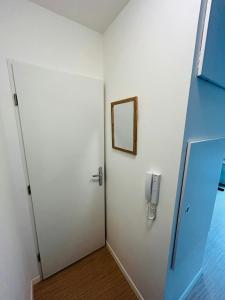ランスにあるWe Live In R - Suite 101の壁に電話が付いたドアのある部屋 +2枚の写真