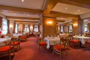 a restaurant with white tables and orange chairs at Landhotel Donner in Meschede