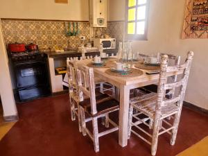 a kitchen with a wooden table and some chairs at Casas de Juella -Juella-Tilcara in Tilcara