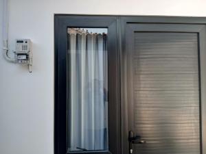 una puerta negra con una ventana y una cortina en Kostel 77 Jepara, en Jepara