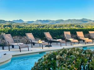 a row of chairs sitting next to a swimming pool at Hostellerie Le Beffroi in Vaison-la-Romaine