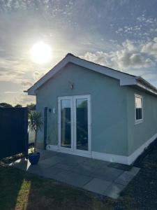 Une petite maison blanche avec une grande porte dans l'établissement The Cosy Cabin, à Pembrokeshire