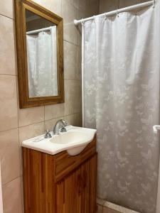 a bathroom with a sink and a shower curtain at Bungalows Plaza Termal in Federación