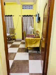 a dining room with a table and a yellow wall at bagga villa in Patna