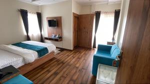 a hotel room with a bed and a blue chair at Devlok Inn in Lohaghāt