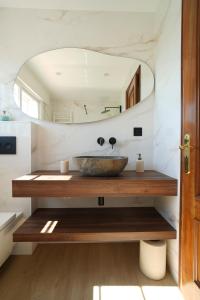 un baño con lavabo y espejo en Casa con jardín en Fefiñanes, Cambados, en Cambados