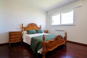 Un dormitorio con una cama y una cómoda y una ventana. en Casa con jardín en Fefiñanes, Cambados, en Cambados