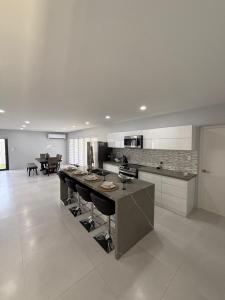 eine Küche mit einer großen Insel mit Barhockern in der Unterkunft Modern Home In Noord in Noord