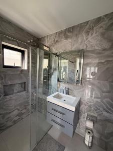 ein Badezimmer mit Waschbecken und Dusche in der Unterkunft Modern Home In Noord in Noord