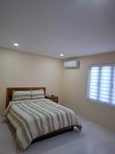 ein Schlafzimmer mit großem Bett und Fenster in der Unterkunft Modern Home In Noord in Noord + 5 Fotos