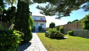 una casa blanca con una valla y un patio en Casa con jardín en Fefiñanes, Cambados, en Cambados