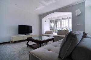 Una sala de estar con un sofá y un televisor. en Casa con jardín en Fefiñanes, Cambados, en Cambados