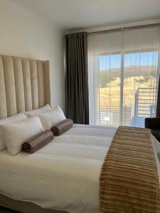 a bedroom with a large bed with a large window at Casa Bliss, Stylish City Escape in Windhoek