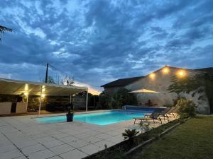 a house with a swimming pool at night at Gîte & Spa Château Lagrange les Tours in Cubzac-les-Ponts