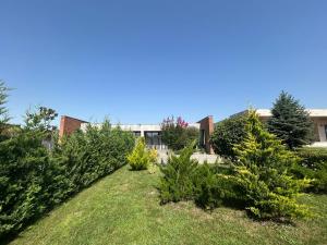 a garden with trees in front of a building at Villa, Kachreti Ambassador Golf Resort in Kachretʼi