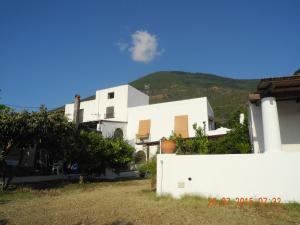 un bâtiment blanc avec une colline en arrière-plan dans l'établissement Note di Salina, à Santa Marina Salina